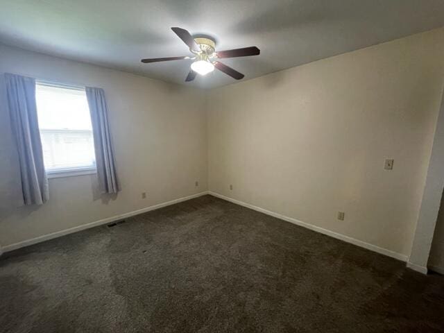 607 Robin Rd, Mountain Grove, MO 65711 - empty room with dark carpet, a ceiling fan, and baseboards