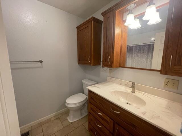 607 Robin Rd, Mountain Grove, MO 65711 - bathroom with vanity, toilet, baseboards, tile patterned floors, and a chandelier