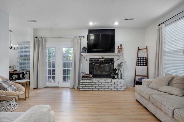 505 Thunderbird Dr, Rogersville, MO 65742 - living room featuring a chandelier, wood finished floors, a glass covered fireplace, and recessed lighting