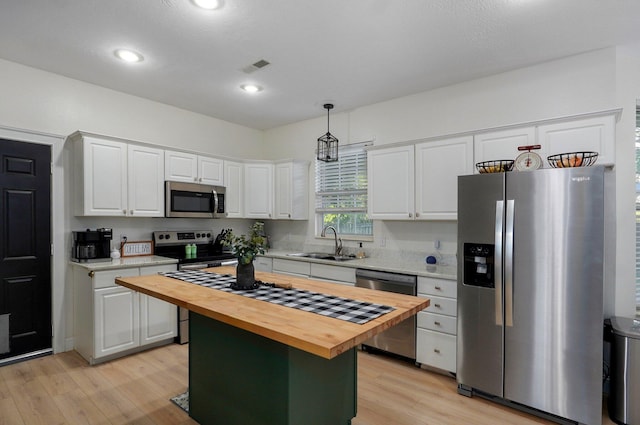 505 Thunderbird Dr, Rogersville, MO 65742 - kitchen featuring stainless steel appliances, wood counters, a sink, white cabinets, and a center island