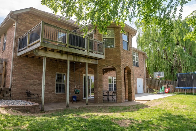 711 Morning Glory Dr, Nixa, MO 65714 - rear view of house featuring a trampoline, a patio, a deck, and brick siding