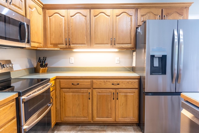 711 Morning Glory Dr, Nixa, MO 65714 - kitchen with stainless steel appliances, light countertops, and brown cabinetry