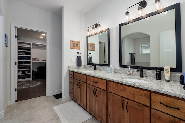 1002 E Tipperary Ct, Nixa, MO 65714 - bathroom with a walk in closet, double vanity, and tile patterned floors