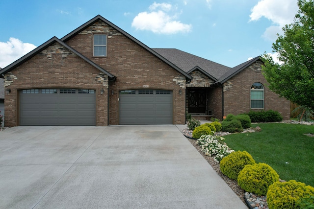 992 N Cedar Ridge Ave, Springfield, MO 65802 - view of front of house featuring driveway, a front yard, brick siding, and an attached garage