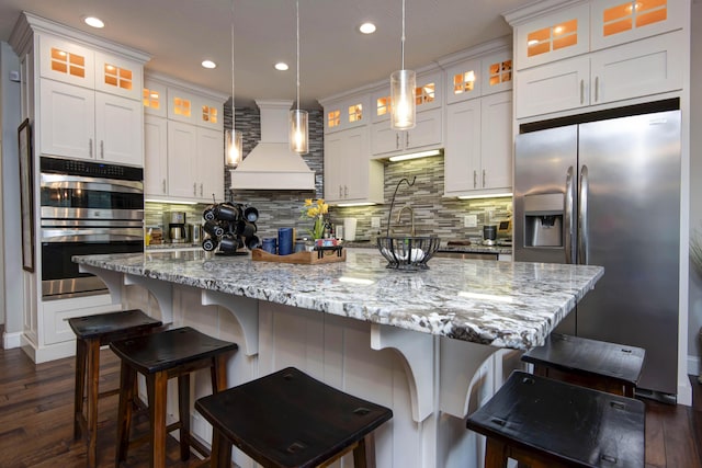 992 N Cedar Ridge Ave, Springfield, MO 65802 - kitchen featuring stainless steel appliances, custom range hood, tasteful backsplash, dark wood-type flooring, and white cabinetry