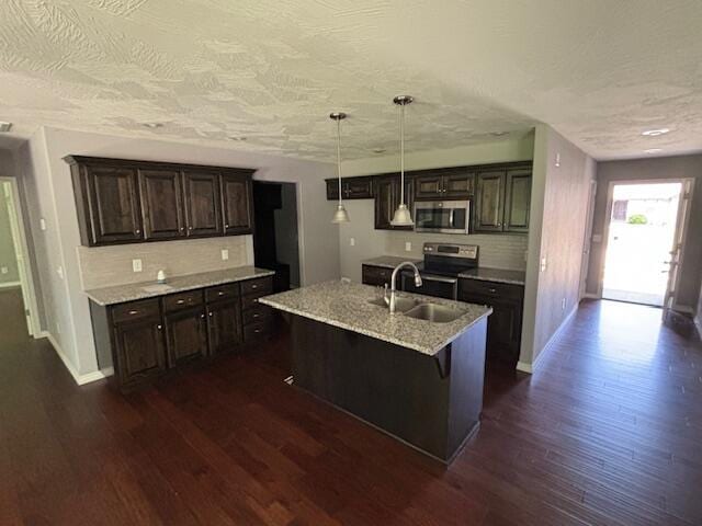 1015 E Lakota St, Nixa, MO 65714 - kitchen featuring appliances with stainless steel finishes, a sink, dark wood-type flooring, backsplash, and a textured ceiling