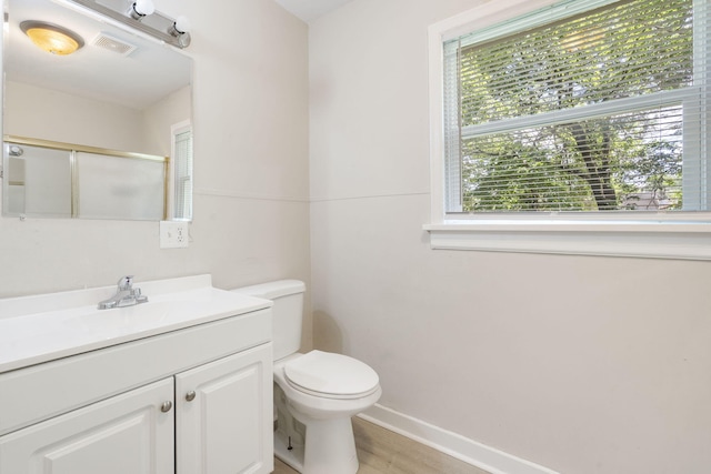 1116 W University St, Springfield, MO 65807 - full bathroom featuring a stall shower, toilet, vanity, baseboards, and wood finished floors