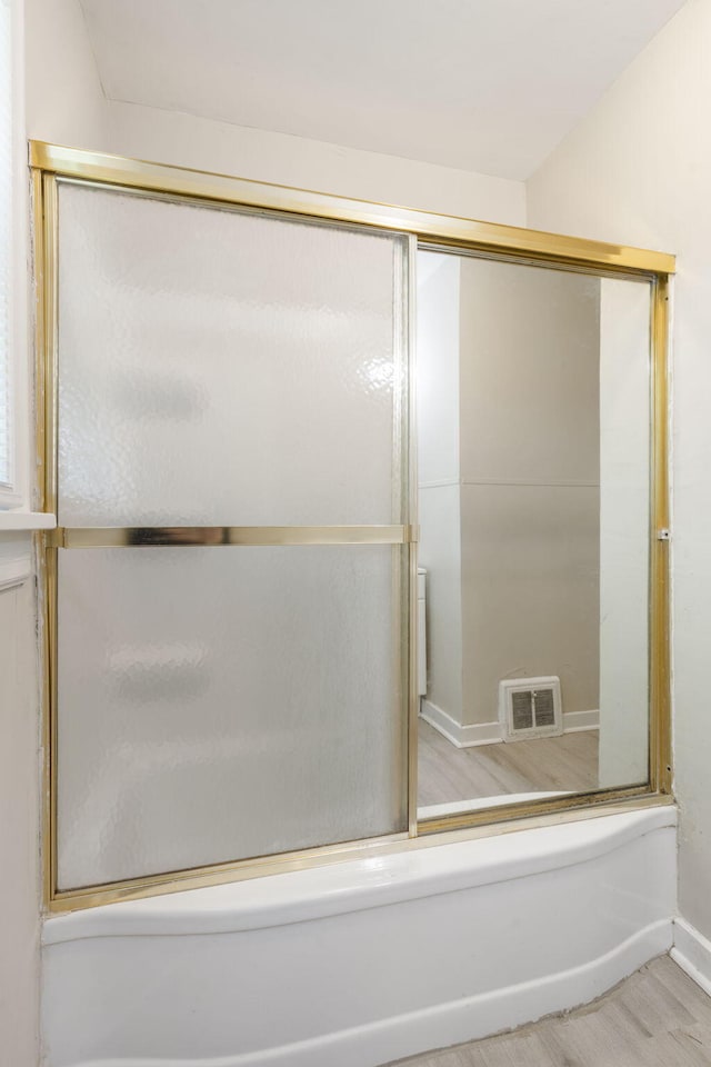 1116 W University St, Springfield, MO 65807 - full bathroom featuring wood finished floors, bath / shower combo with glass door, and baseboards