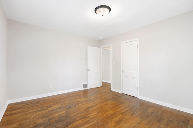 1116 W University St, Springfield, MO 65807 - empty room with wood finished floors and baseboards