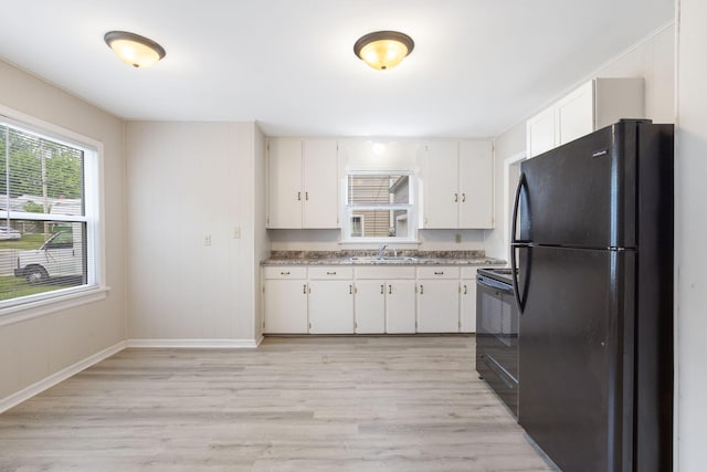 1116 W University St, Springfield, MO 65807 - kitchen with black appliances, a sink, light wood-style flooring, white cabinetry, and baseboards