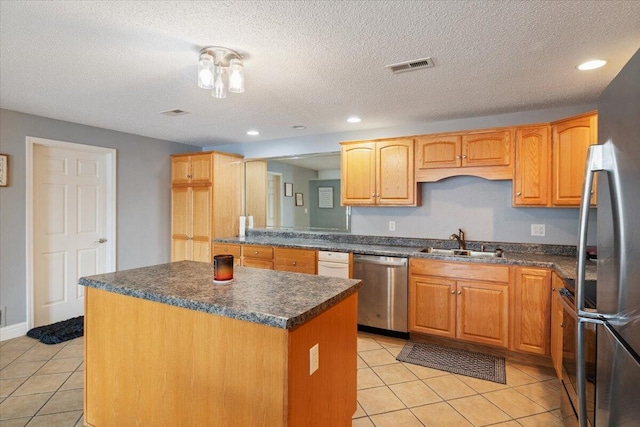 783 Winn Rd Unit 5B, Osage Beach, MO 65065 - kitchen featuring stainless steel appliances, a sink, dark countertops, light tile patterned floors, and a kitchen island