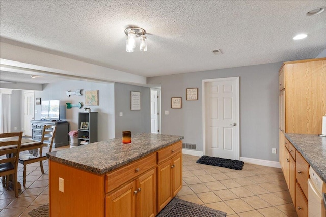 783 Winn Rd Unit 5B, Osage Beach, MO 65065 - kitchen with light tile patterned flooring, dark countertops, dishwashing machine, a center island, and baseboards