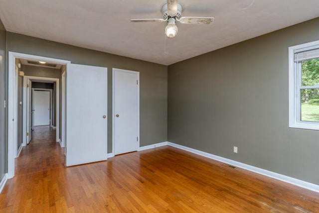 1318 S Farm Rd Unit 205, Springfield, MO 65809 - unfurnished bedroom with baseboards, light wood finished floors, and ceiling fan