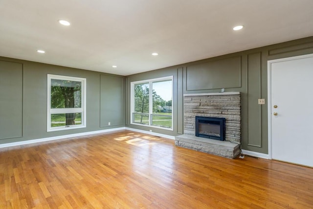 1318 S Farm Rd Unit 205, Springfield, MO 65809 - unfurnished living room featuring a decorative wall, light wood-type flooring, recessed lighting, and a fireplace