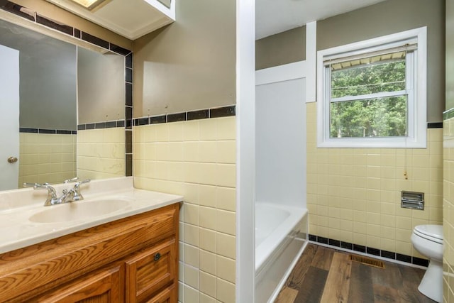1318 S Farm Rd Unit 205, Springfield, MO 65809 - full bath with tile walls, toilet, wood finished floors, a tub, and vanity