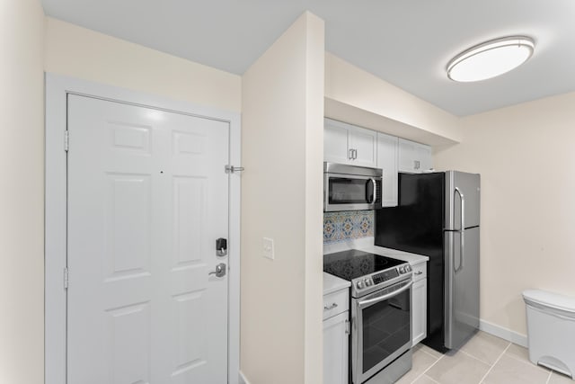 264 Turnberry Dr Unit 2, Branson, MO 65615 - kitchen featuring appliances with stainless steel finishes, light countertops, baseboards, light tile patterned floors, and white cabinets