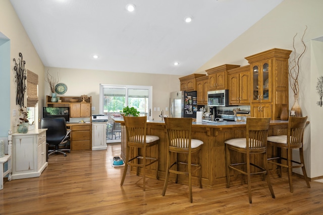 1362 Meadowview Ln, Diamond, MO 64840 - kitchen with stainless steel appliances, brown cabinetry, light wood-type flooring, glass insert cabinets, and a peninsula
