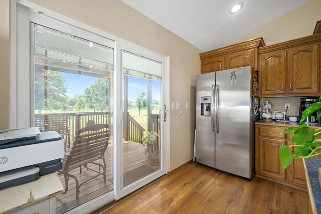 1362 Meadowview Ln, Diamond, MO 64840 - kitchen with stainless steel refrigerator with ice dispenser, vaulted ceiling, brown cabinets, light wood finished floors, and recessed lighting