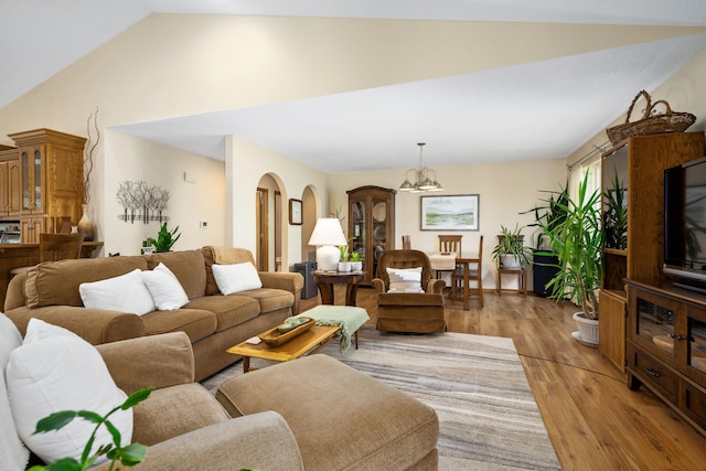 1362 Meadowview Ln, Diamond, MO 64840 - living room featuring a chandelier, vaulted ceiling, light wood-type flooring, and arched walkways