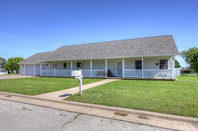 707 Lexie Ln, Carthage, MO 64836 - view of front of house with covered porch, driveway, an attached garage, and a front yard