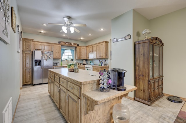 707 Lexie Ln, Carthage, MO 64836 - kitchen featuring white appliances, light wood-style flooring, ceiling fan, light countertops, and a kitchen island