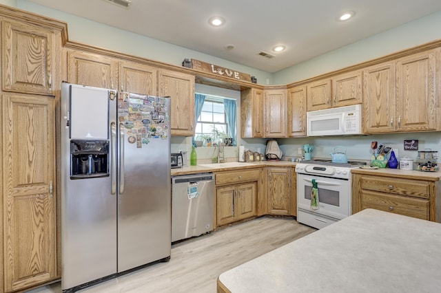 707 Lexie Ln, Carthage, MO 64836 - kitchen with stainless steel appliances, light countertops, light wood-style floors, a sink, and recessed lighting