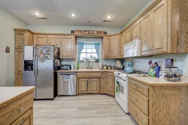 707 Lexie Ln, Carthage, MO 64836 - kitchen with stainless steel appliances, light countertops, light wood-style flooring, recessed lighting, and a sink