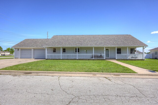 707 Lexie Ln, Carthage, MO 64836 - view of front of house with covered porch, an attached garage, concrete driveway, and a front yard