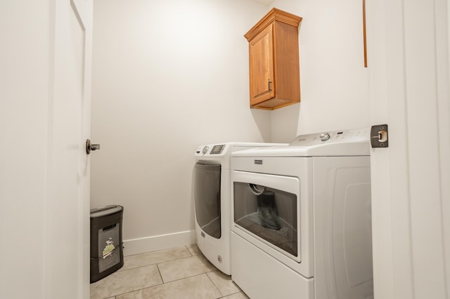 4738 N Florence Ave, Ozark, MO 65721 - laundry area featuring washer and clothes dryer, cabinet space, light tile patterned floors, and baseboards