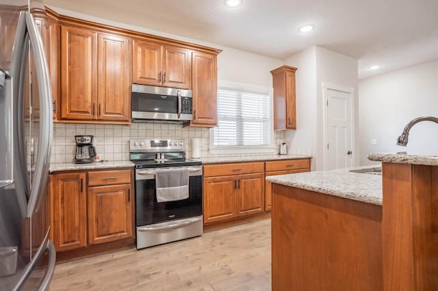4738 N Florence Ave, Ozark, MO 65721 - kitchen with appliances with stainless steel finishes, brown cabinetry, decorative backsplash, light wood-style floors, and recessed lighting