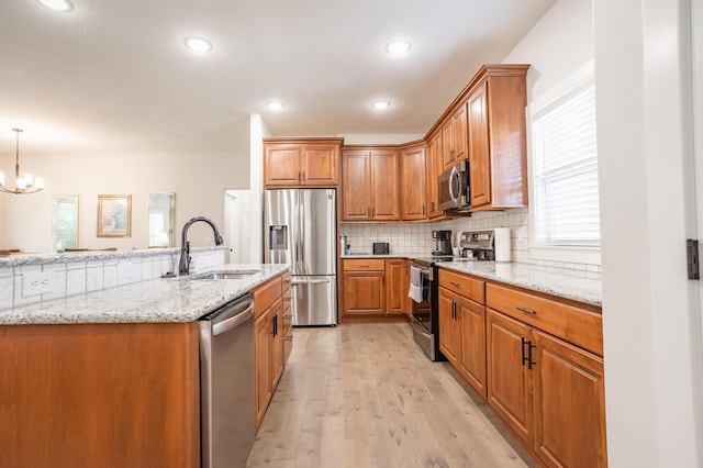 4738 N Florence Ave, Ozark, MO 65721 - kitchen with stainless steel appliances, a sink, brown cabinetry, light stone counters, and tasteful backsplash