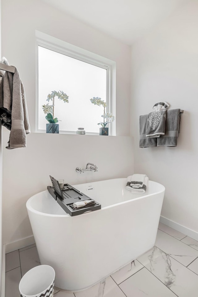 4786 E Whitman Rd, Springfield, MO 65802 - bathroom with baseboards, a freestanding tub, and marble look tile flooring