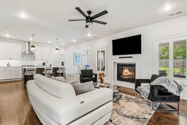 4786 E Whitman Rd, Springfield, MO 65802 - living room featuring a ceiling fan, a glass covered fireplace, dark wood-type flooring, and recessed lighting