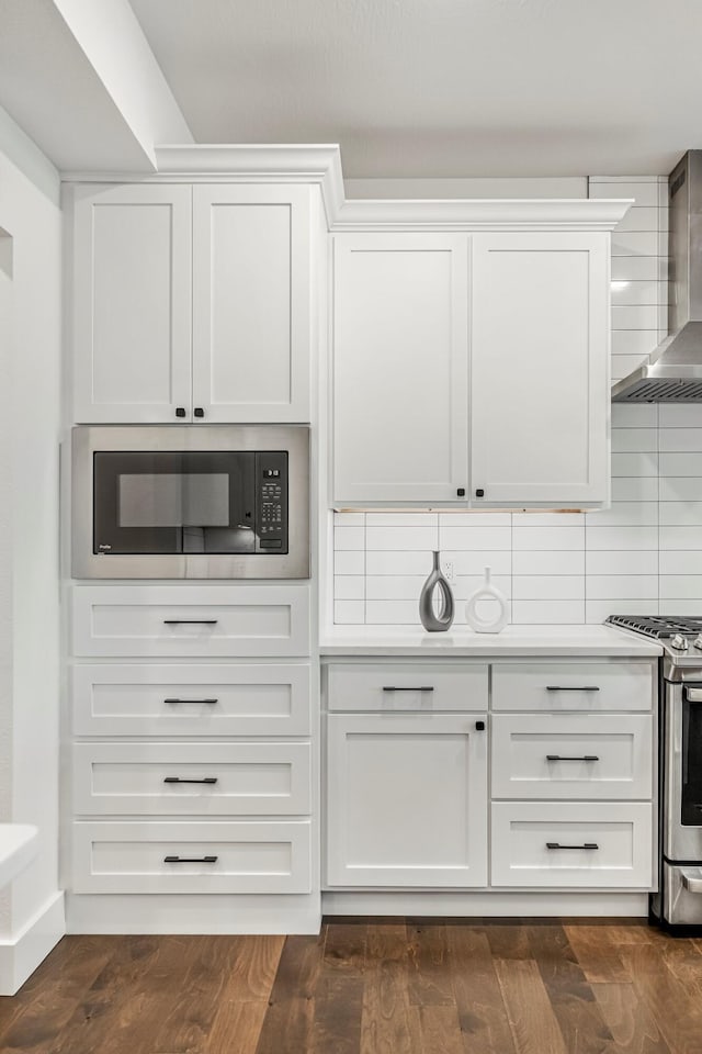 4786 E Whitman Rd, Springfield, MO 65802 - kitchen featuring stainless steel range with gas stovetop, wall chimney range hood, built in microwave, and white cabinetry