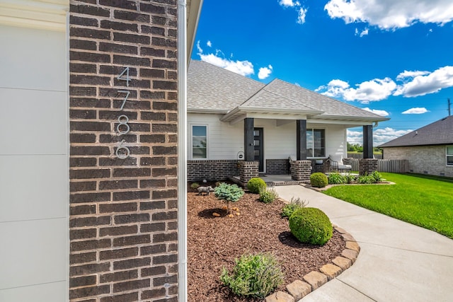 4786 E Whitman Rd, Springfield, MO 65802 - view of front facade with covered porch, a shingled roof, and brick siding