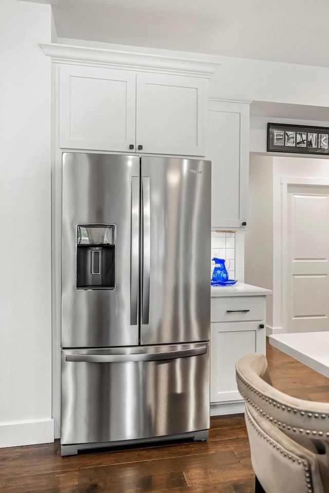 4786 E Whitman Rd, Springfield, MO 65802 - kitchen view of stainless steel fridge with ice dispenser, dark wood-style floors, tasteful backsplash, and white cabinetry
