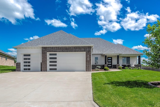 4786 E Whitman Rd, Springfield, MO 65802 - view of front of house with brick siding, an attached garage, a front lawn, and a shingled roof