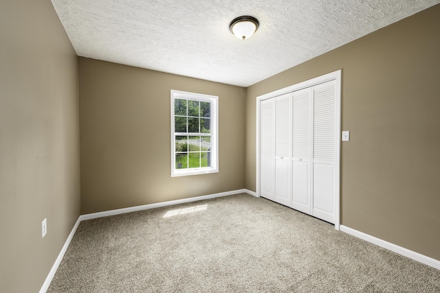 2800 State Highway Bb, Hollister, MO 65672 - unfurnished bedroom featuring carpet flooring, a closet, a textured ceiling, and baseboards