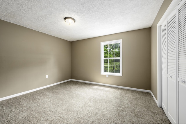 2800 State Highway Bb, Hollister, MO 65672 - unfurnished bedroom with carpet floors, a closet, baseboards, and a textured ceiling