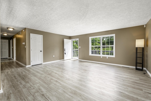 2800 State Highway Bb, Hollister, MO 65672 - unfurnished living room with a textured ceiling, baseboards, and light wood-style floors