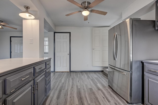 511 N E, Columbus, KS 66725 - kitchen with freestanding refrigerator, ceiling fan, light wood-style floors, light countertops, and gray cabinets