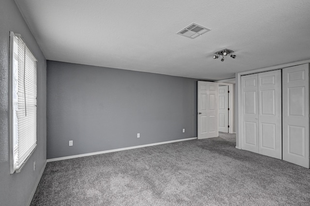511 N E, Columbus, KS 66725 - unfurnished bedroom featuring baseboards, carpet floors, a closet, and a textured ceiling