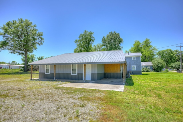511 N E, Columbus, KS 66725 - view of front of house with a front yard, a carport, and metal roof