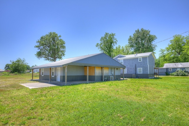 511 N E, Columbus, KS 66725 - back of property with a yard, metal roof, and a patio area
