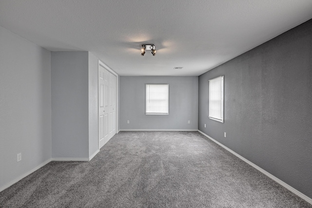 511 N E, Columbus, KS 66725 - unfurnished bedroom with carpet floors, baseboards, a textured ceiling, and a closet