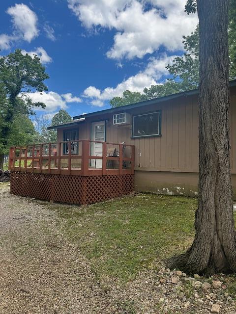 TBD Kings Cove Ln Unit 16, Reeds Spring, MO 65737 - back of house with a wooden deck, a wall mounted AC, and a lawn