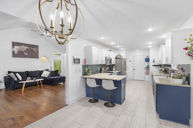 604 N Cascades Dr, Nixa, MO 65714 - kitchen featuring a chandelier, stainless steel appliances, decorative backsplash, a peninsula, and open floor plan