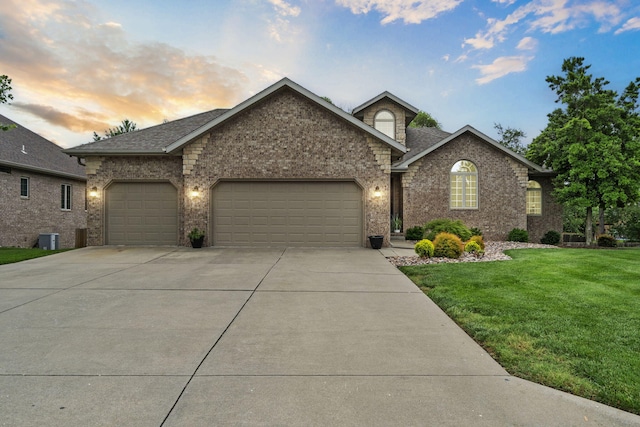604 N Cascades Dr, Nixa, MO 65714 - view of front facade with concrete driveway, a garage, a front lawn, brick siding, and central AC unit
