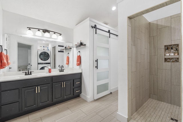 604 N Cascades Dr, Nixa, MO 65714 - bathroom with stacked washer / drying machine, double vanity, a tile shower, and baseboards