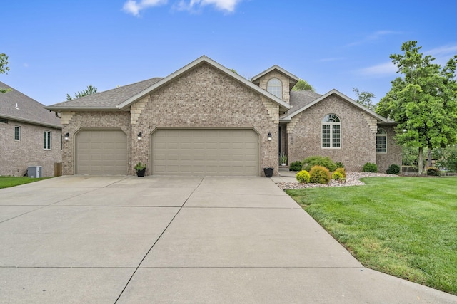 604 N Cascades Dr, Nixa, MO 65714 - view of front of property with an attached garage, driveway, a front yard, brick siding, and a shingled roof